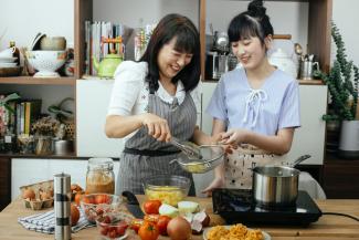 Mother and daughter cooking and laughing